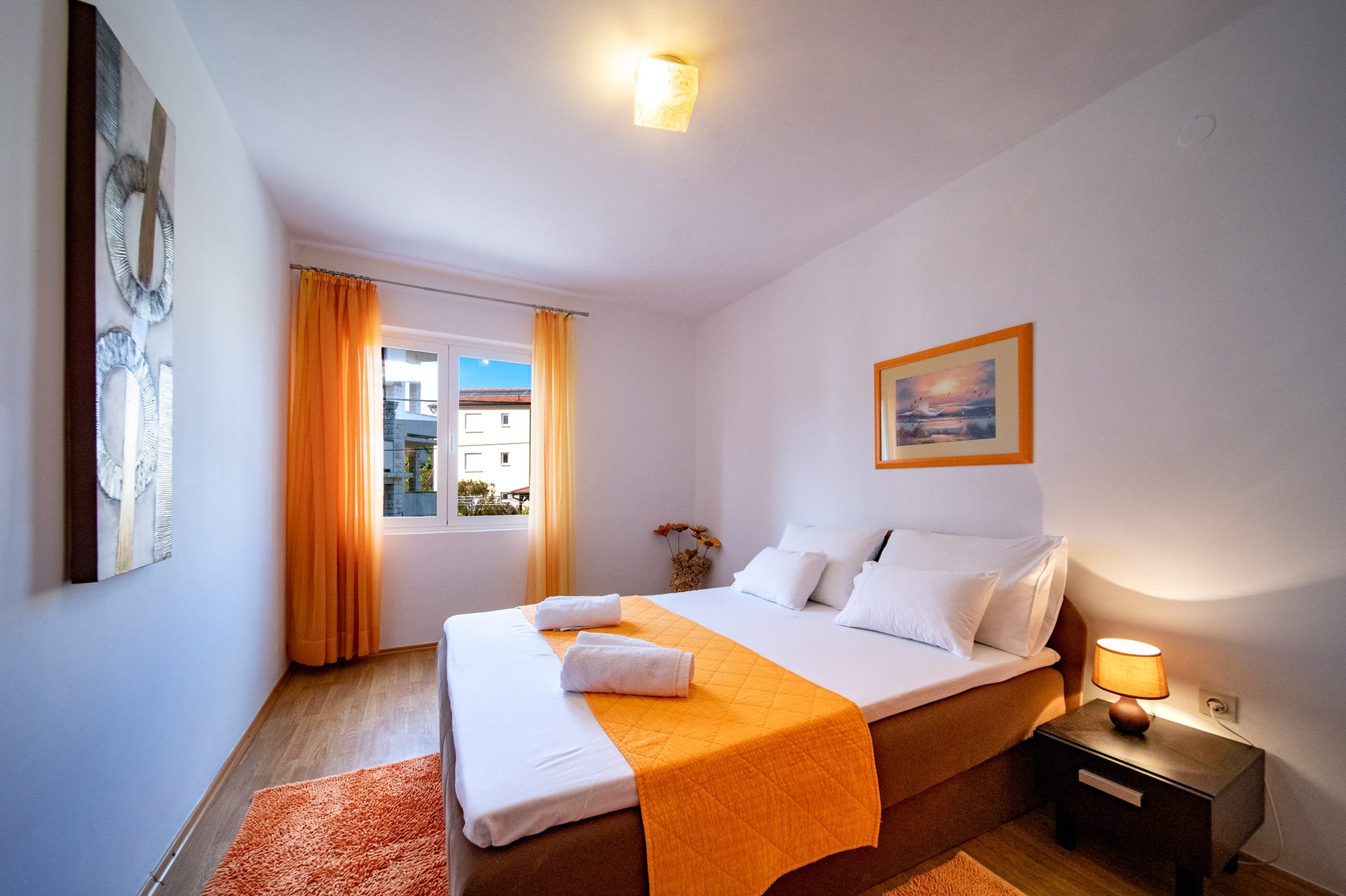 Spavaća soba s narančastim akcentima u Apartmanu 2