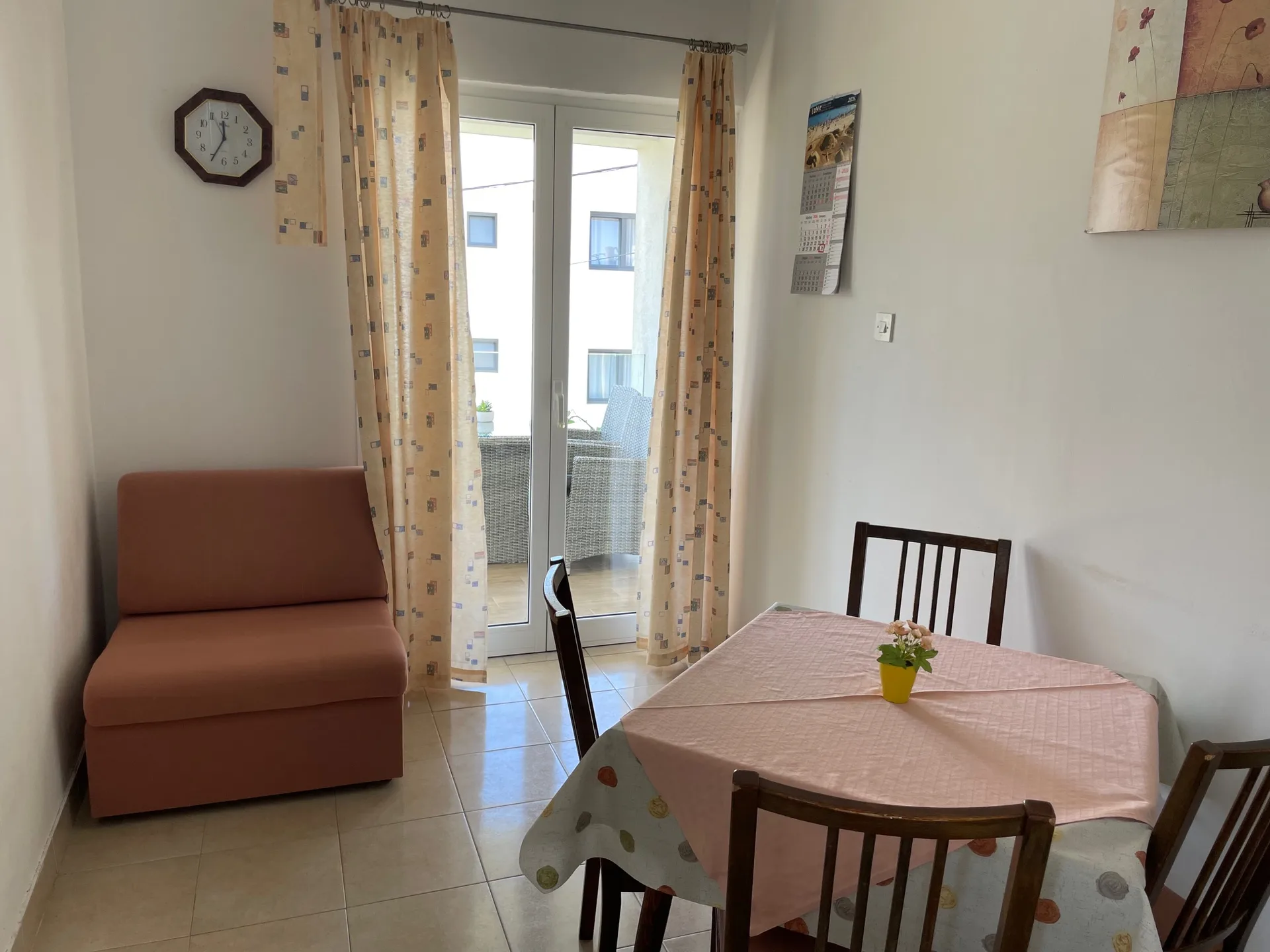 Dining area with a sofa and balcony door.