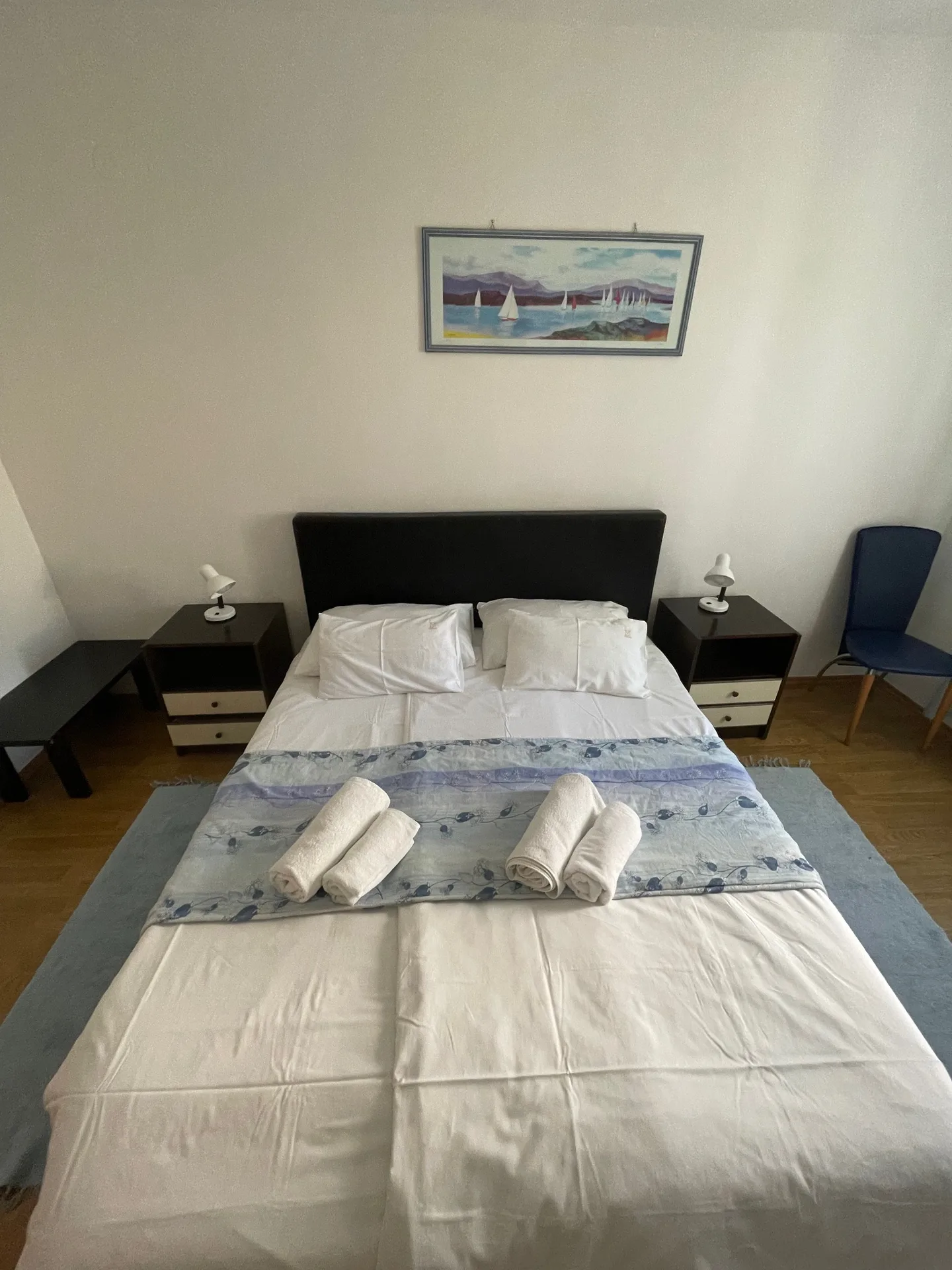 Spavaća soba s plavom posteljinom i noćnim ormarićima u Apartmanu 2.