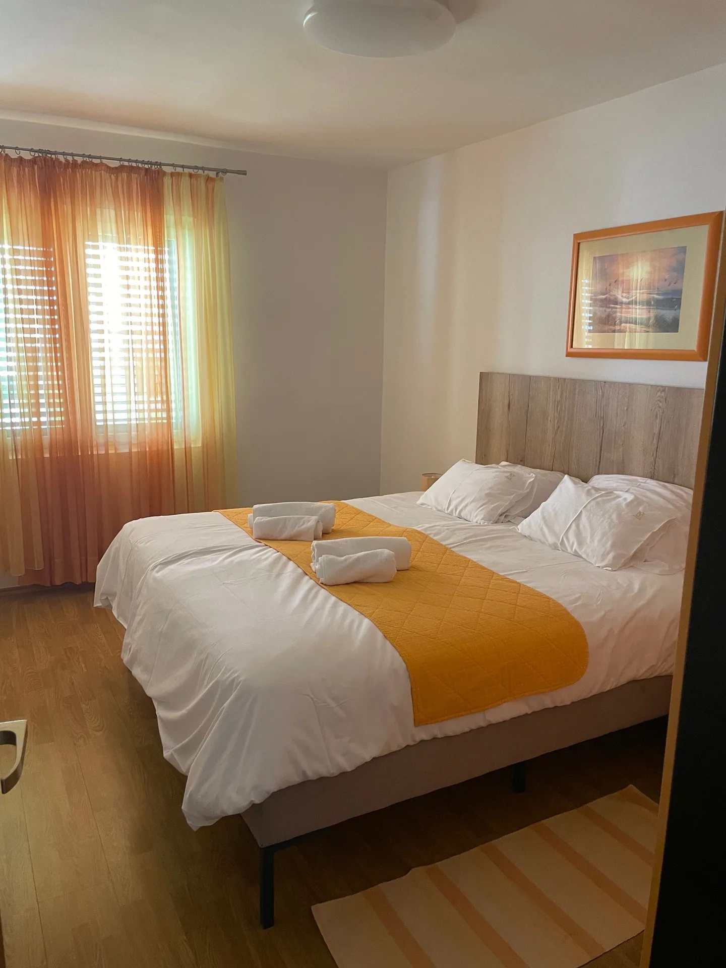 Spavaća soba s bračnim krevetom i žutim prekrivačem u Apartmanu 2.